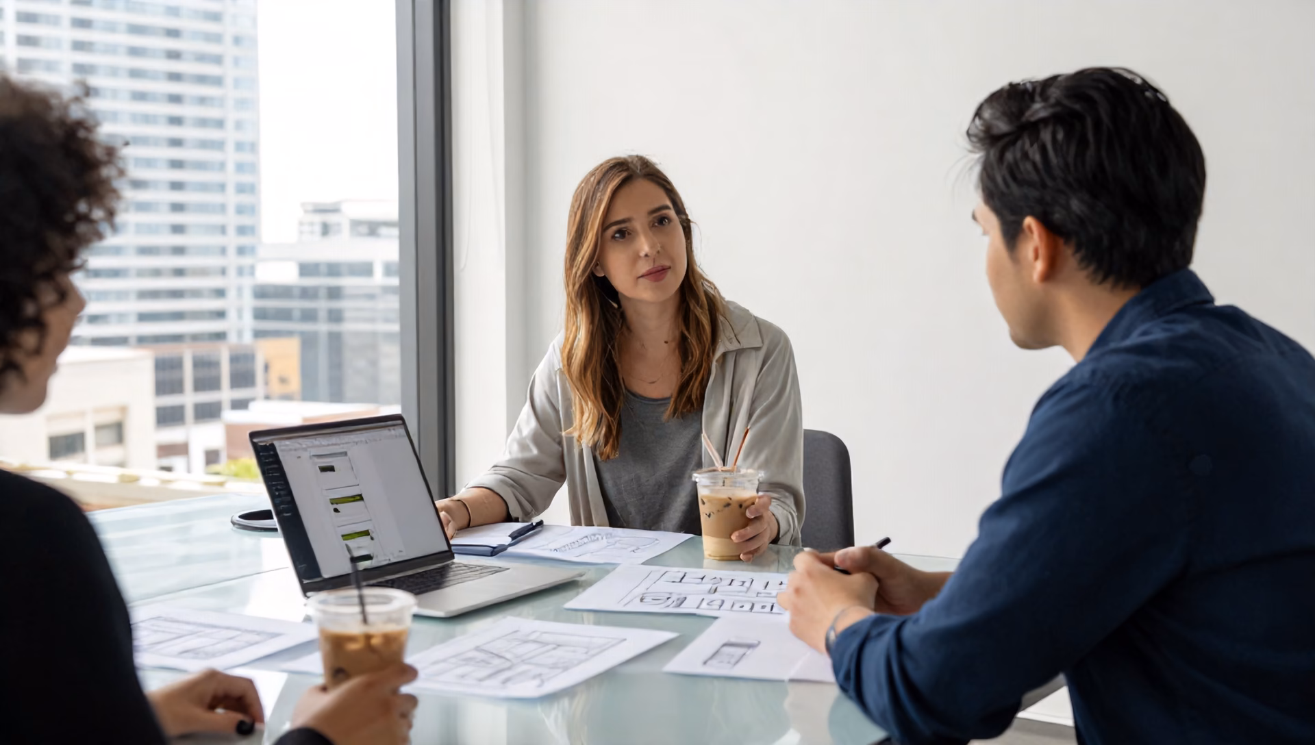 A local business owner and a web strategist. A bright, modern office overlooking the Tampa skyline, with a large glass table covered in printed wireframe sketc…